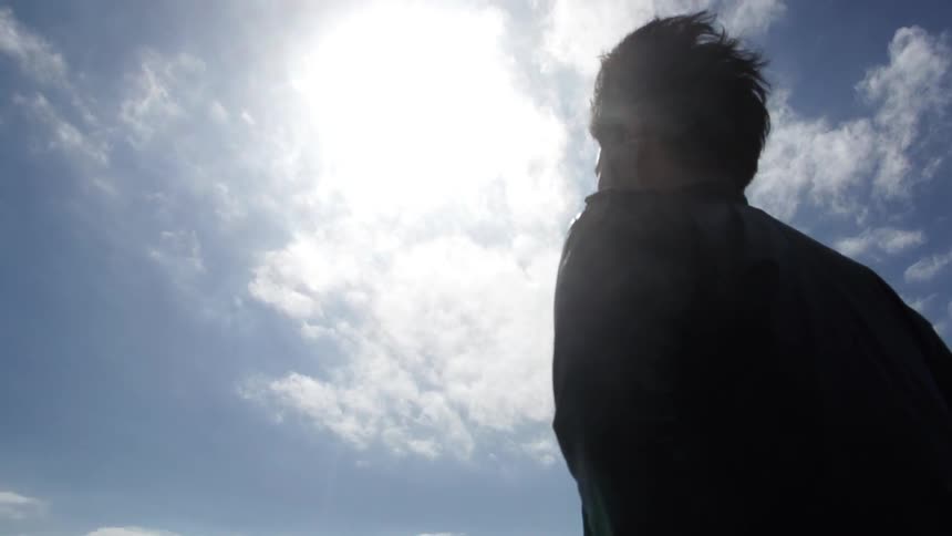 Man standing under a cloudy sky