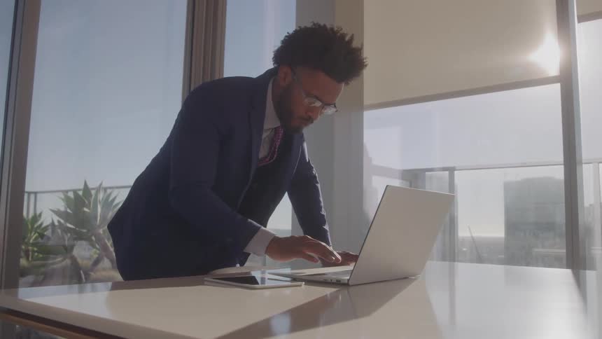 The man is typing on his keyboard in the office