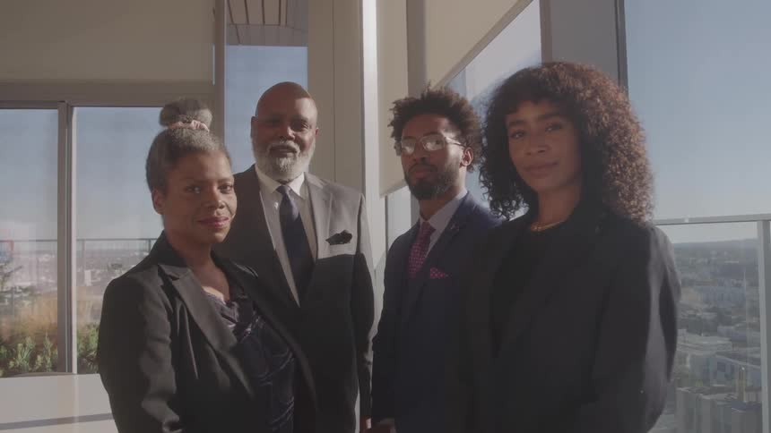 People are standing posed by the window in the office