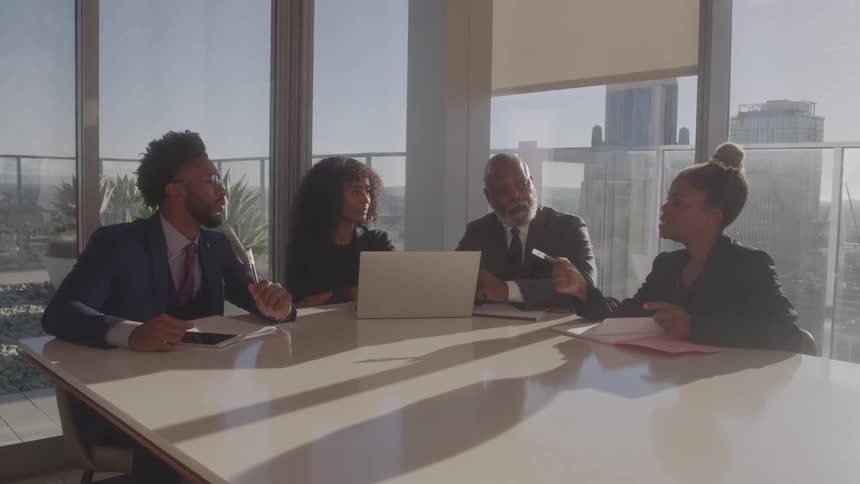 Coworkers point and talk during the meeting