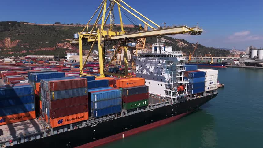 A cargo ship is loaded with containers at a busy port