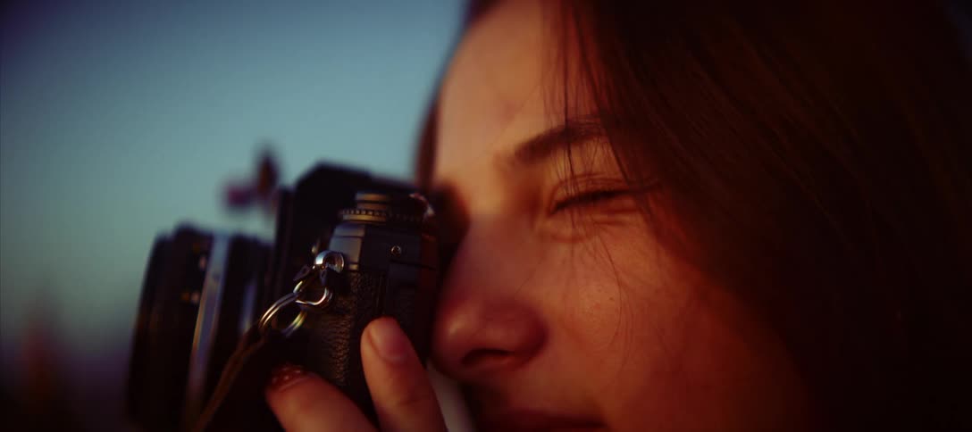 A woman takes photos with a camera outdoors
