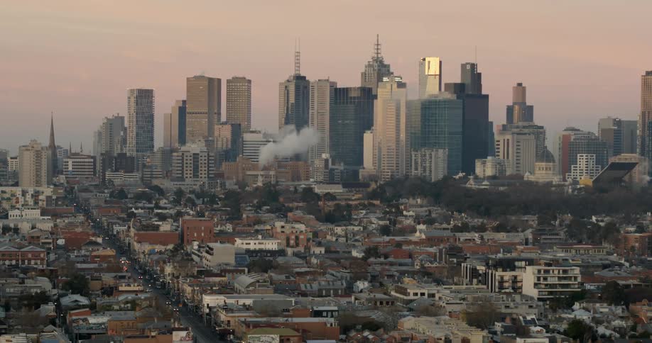 A view of a large city and it's buildings with smoke coming from one building