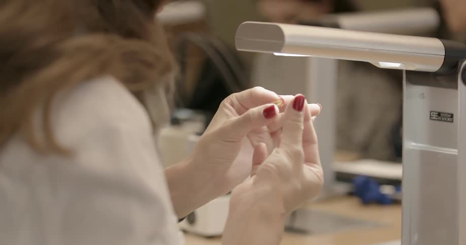 A person examines something under a lamp