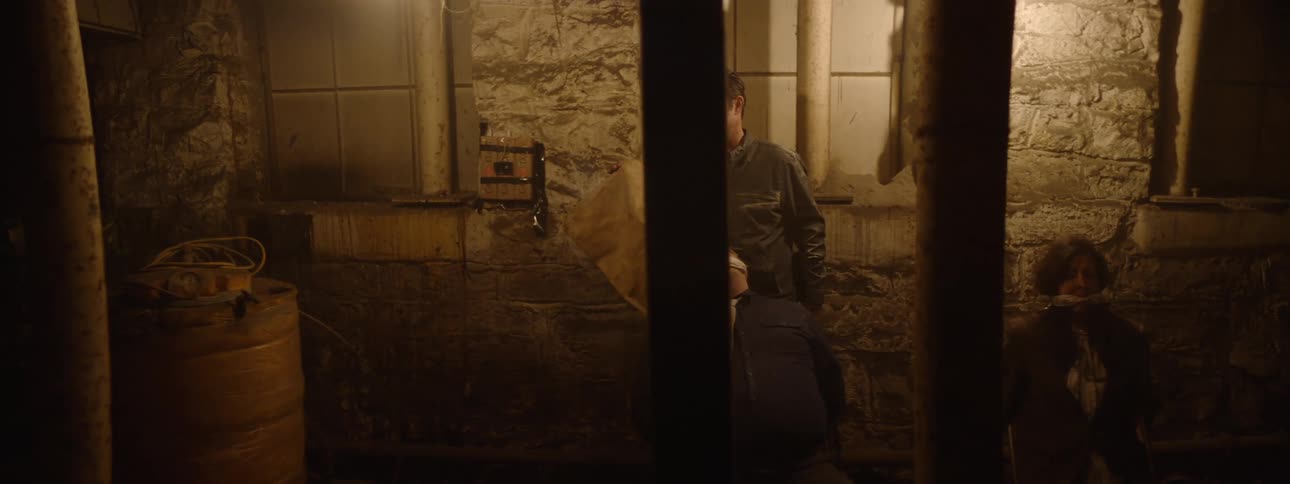 Man removing the hoods of three people kneeling