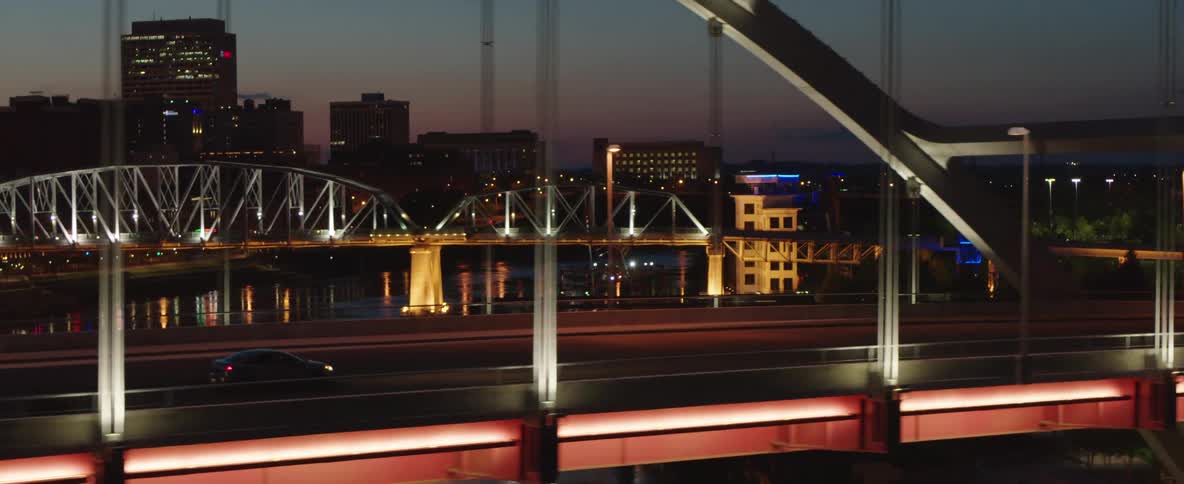 A vehicle travels along a city freeway in the dark of night