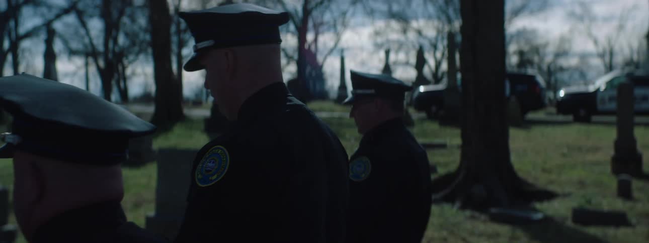 Police officers are at a burial ceremony in the graveyard