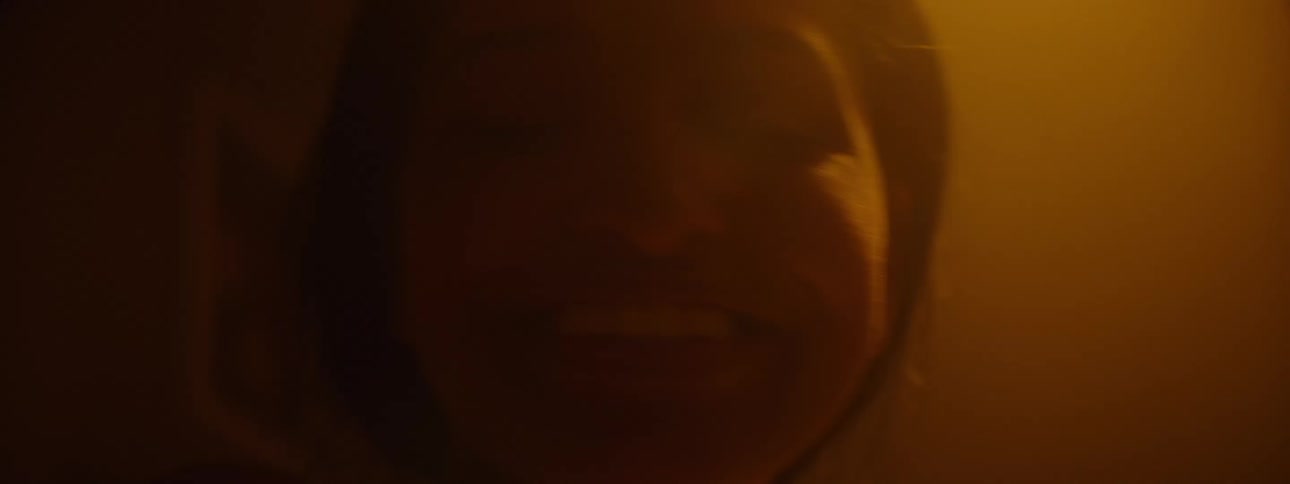 The woman smiles in the dark room