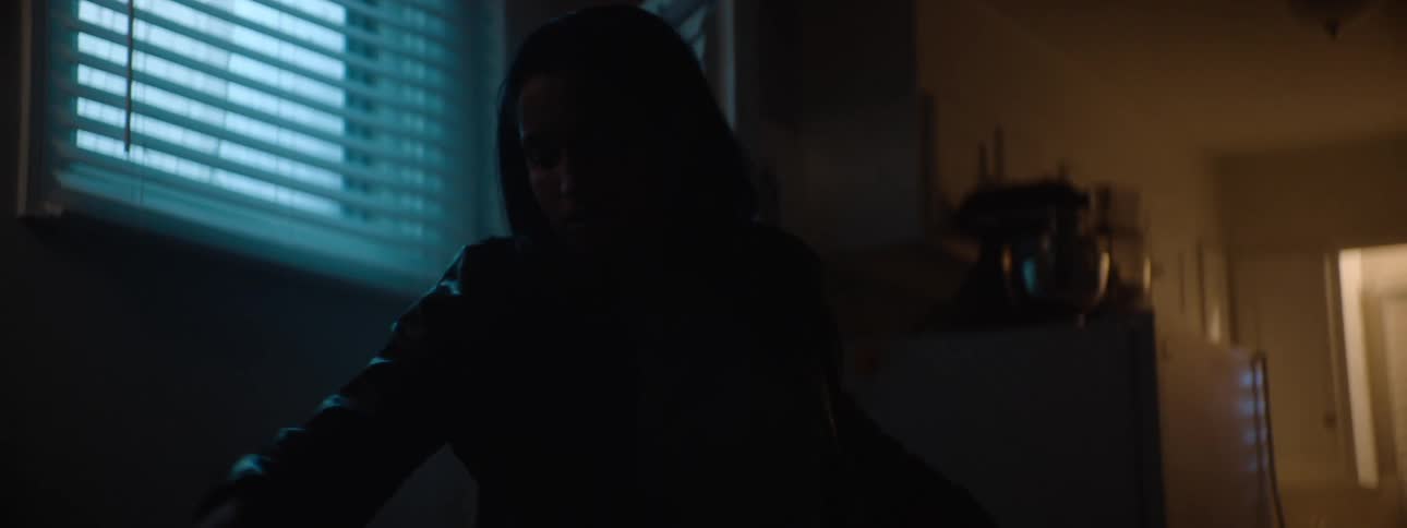 The woman enters her home and reads her mail