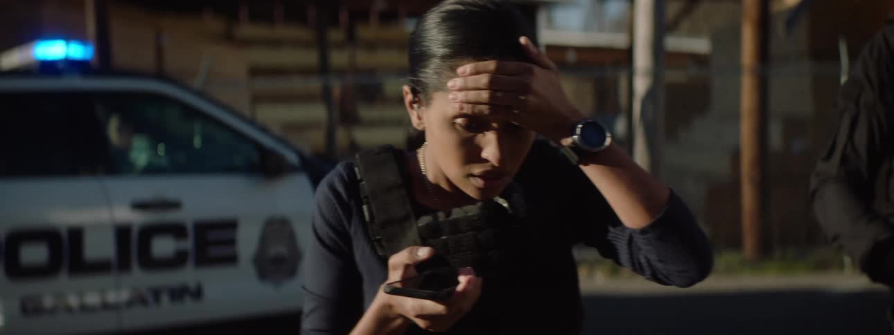 A female police officer looks nervous while talking on her cell phone
