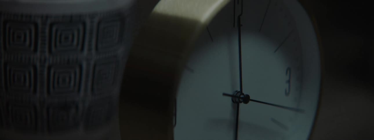 Clock with moving hands on top of a wooden dresser