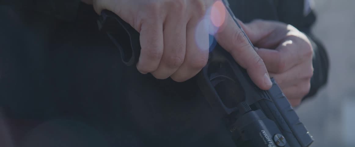 Police officer in sunglasses with his gun cocked