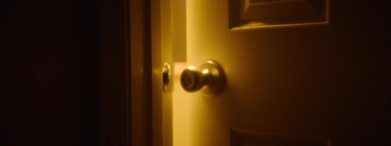 The door is cracked open at the end of the hallway