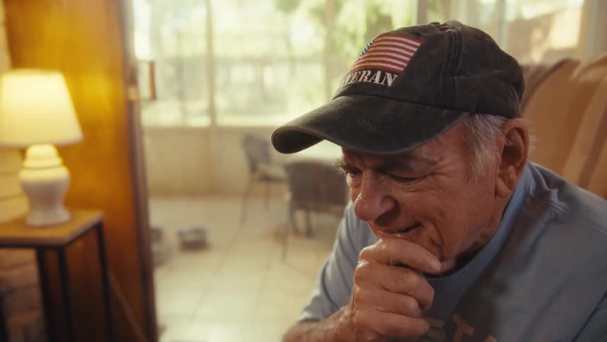 Elderly man sitting interacting with smartphone