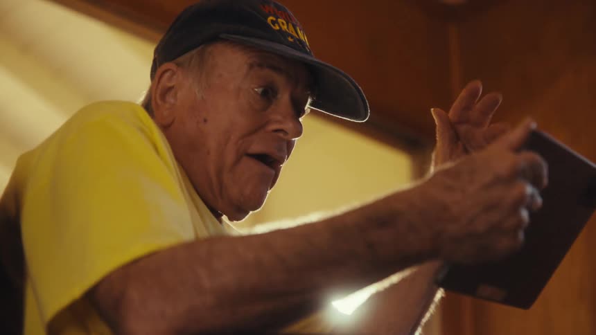 Elderly man vibrantly interacting with a tablet