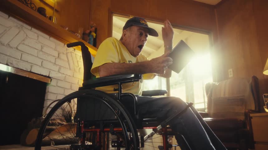 Happy vibrating elderly man interacting with a tablet