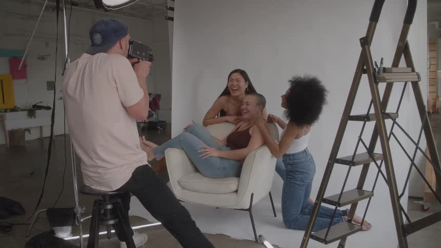 Three girls pose for a cameraman