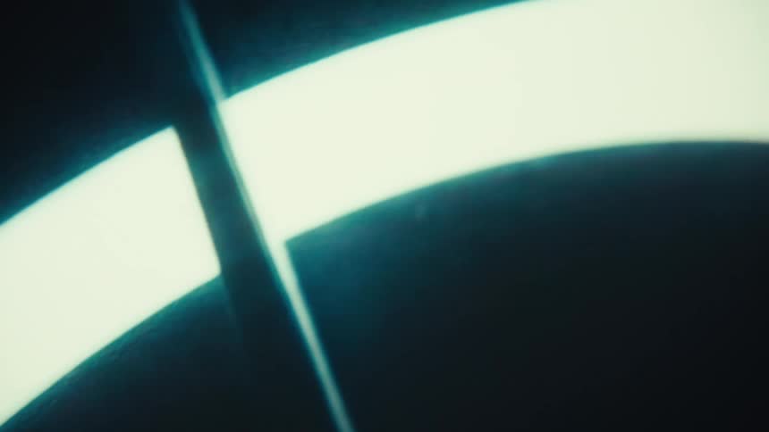 Closeup of a screen displaying a glowing curved light on a dark background