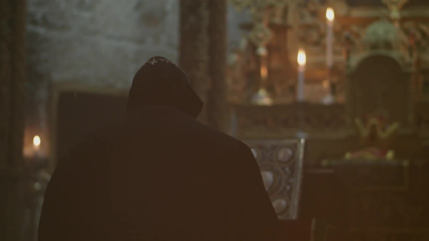 A priest is standing near an altar