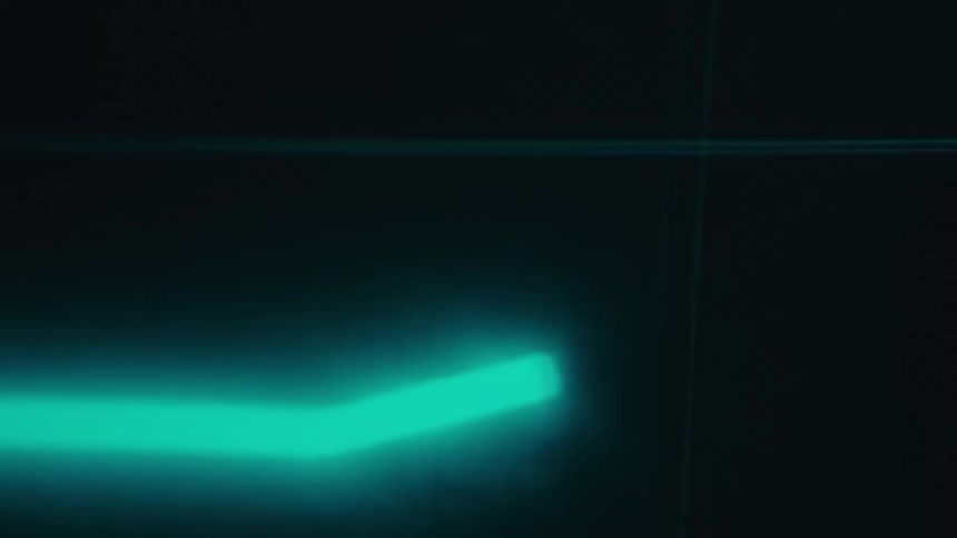 A glowing blue light streak cuts across a dark background