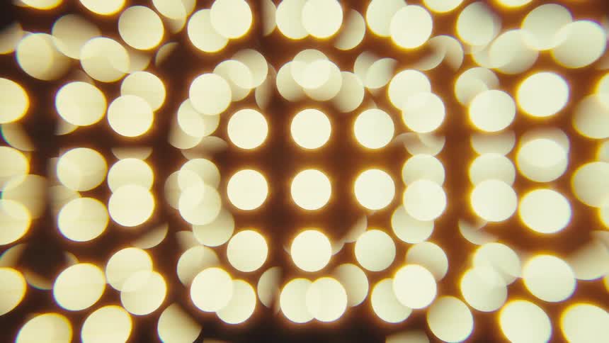 Out of focus light spots arranged in a circular pattern on an orange background