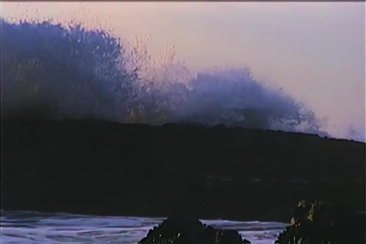 Large waves crash on the rocks of the shore