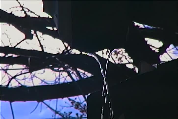 The first line shows a static eyelevel shot of a bare tree branch against a bright blue sky the second line is a closeup of water dripping from an unseen source with the background of the tree branches still visible