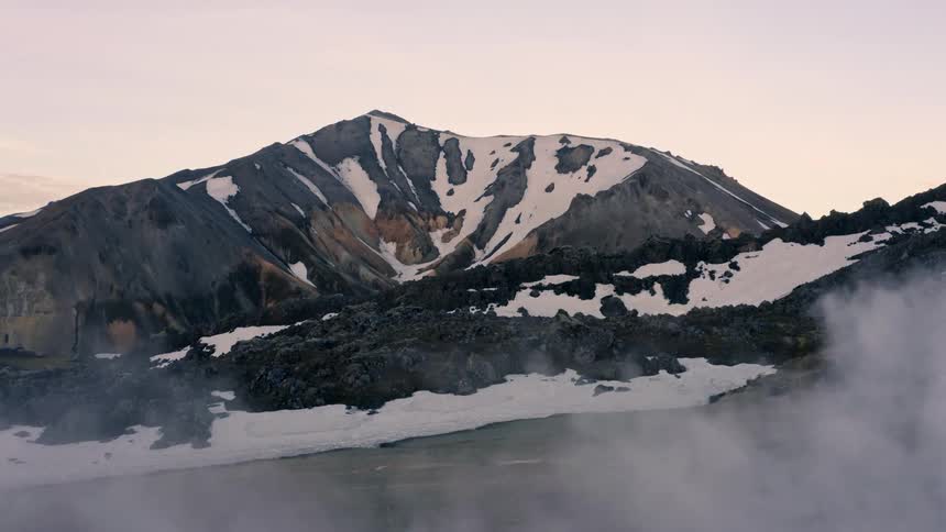 A mountain range in winter with slopes covered in snow at midday