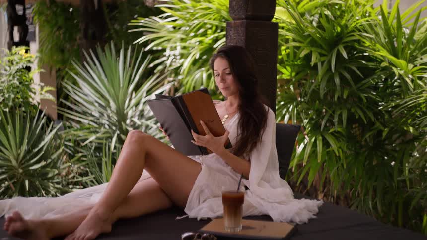 The woman picks up the menu outside at the resort