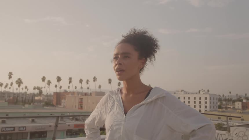 The woman breaths heavily on the rooftop