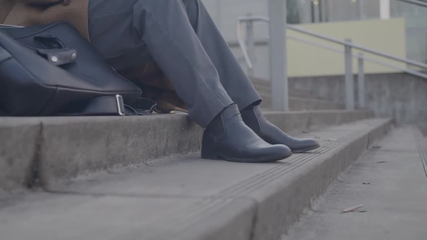 The man sits on the concrete steps