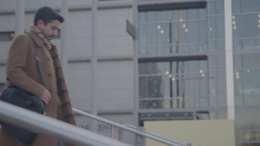 A man walks down some steps by a building