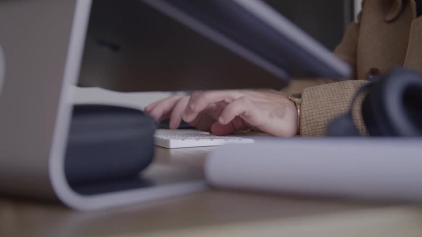 The man types on his computer in the office