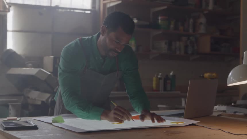 The man taps his pencil and writes