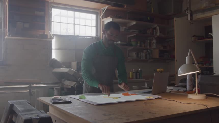 The man types on his laptop then writes with a pencil