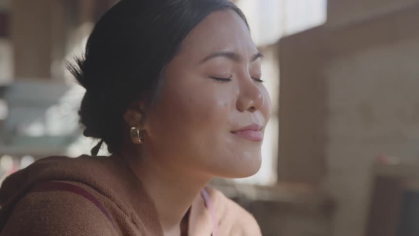 The woman is smiling and blinking