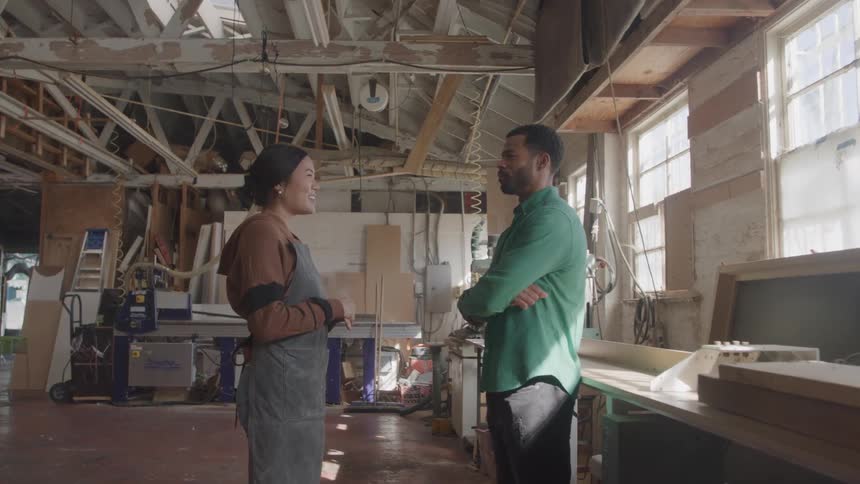 Man and a woman talking inside a factory