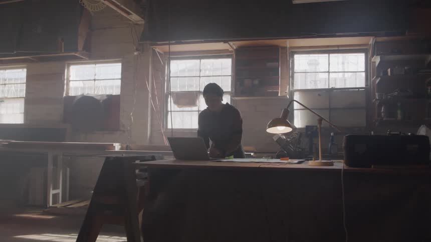 Woman opening a laptop and starting to type at a table