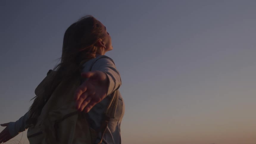A woman standing outside with her arms outstretched