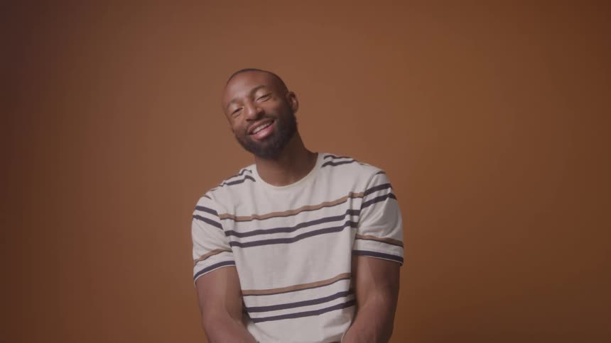 The man is sitting and laughing