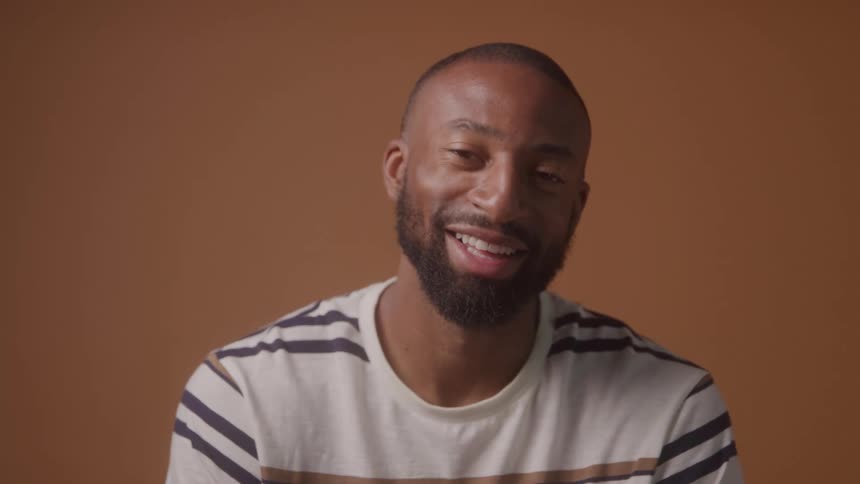 A man laughs and smiles at the camera