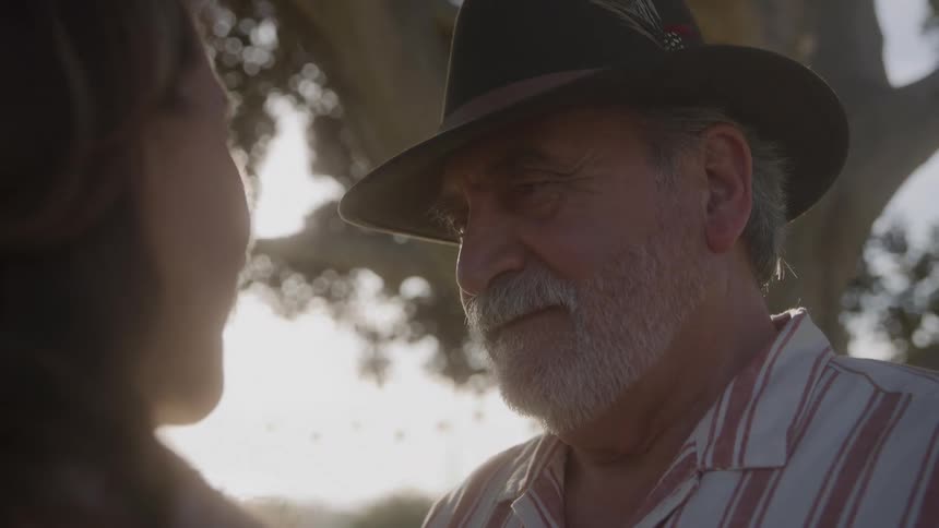 Man in a hat smiles while looking at his partner