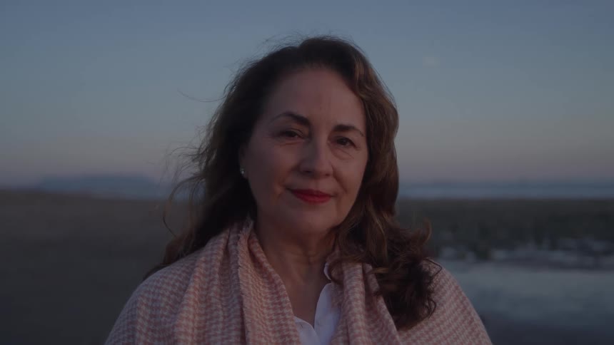 The woman is smiling on the beach