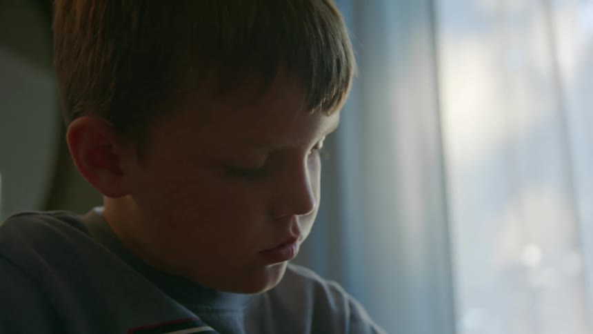 Boy looking down with a focused expression