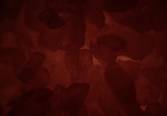 Reddish stones illuminated resemble glowing mineral formations