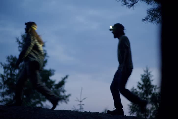 Two people hike in the night