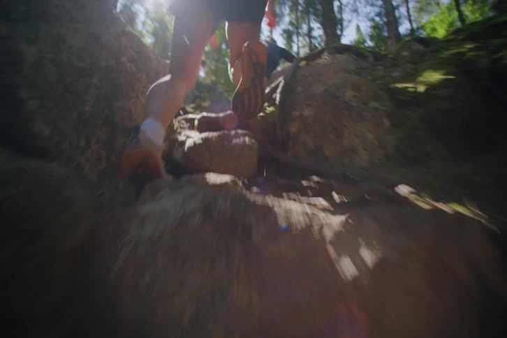 Person wearing sneakers runs up a steep trail in the forest
