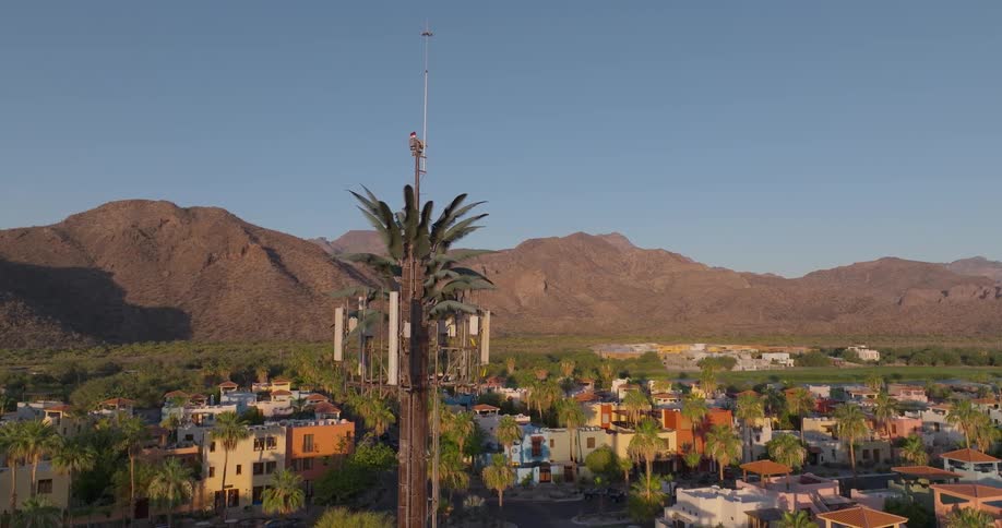 Aerial view of suburbs with distant mountains under a bright sky