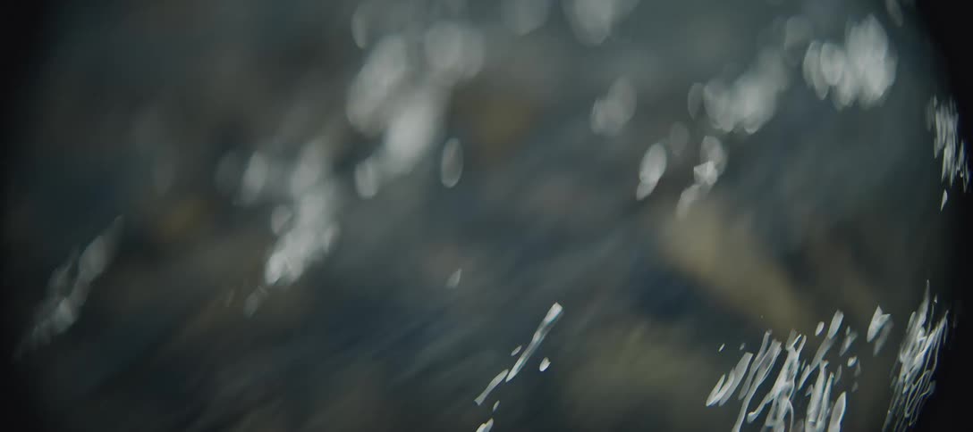 Closeup of frothy water rushing over rocks in a river