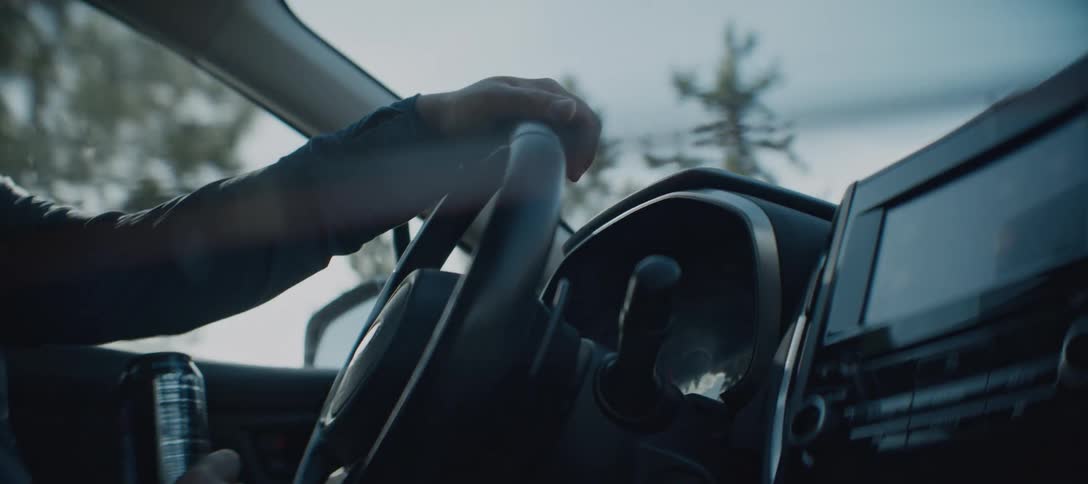 The man drinks from his thermos while driving